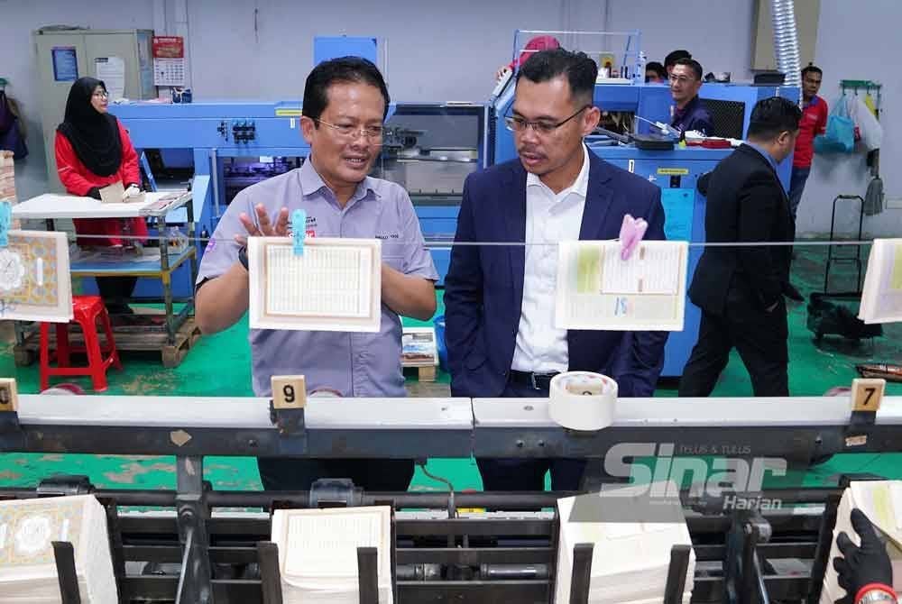 Mohd Fauzi (kanan) mendengar penerangan berkaitan percetakan al-Quran daripada Ahmad Yani. Foto Sinar Harian-MOHD HALIM ABDUL WAHID