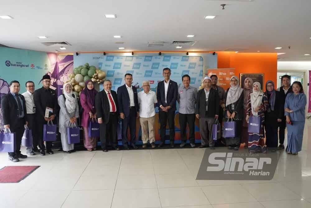 (Tujuh dari kiri) Mohd Fauzi, Penasihat Kumpulan Karangkraf, Datuk Hussamuddin Yaacub; Pengurus Bahagian Pembangunan Asnaf, Ahmad Saifuddin Md Tahir @ Twahir dan Ahmad Yani bersama barisan pengurusan MAIWP bergambar selepas sesi lawatan ke Kompleks Kumpulan Karangraf pada Isnin.