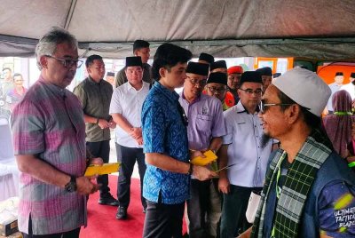 Al-Sultan Abdullah dan Tengku Hassanal berkenan menyerahkan sumbangan kepada mangsa banjir di Dewan Orang Kampung Tok Machang pada Isnin.