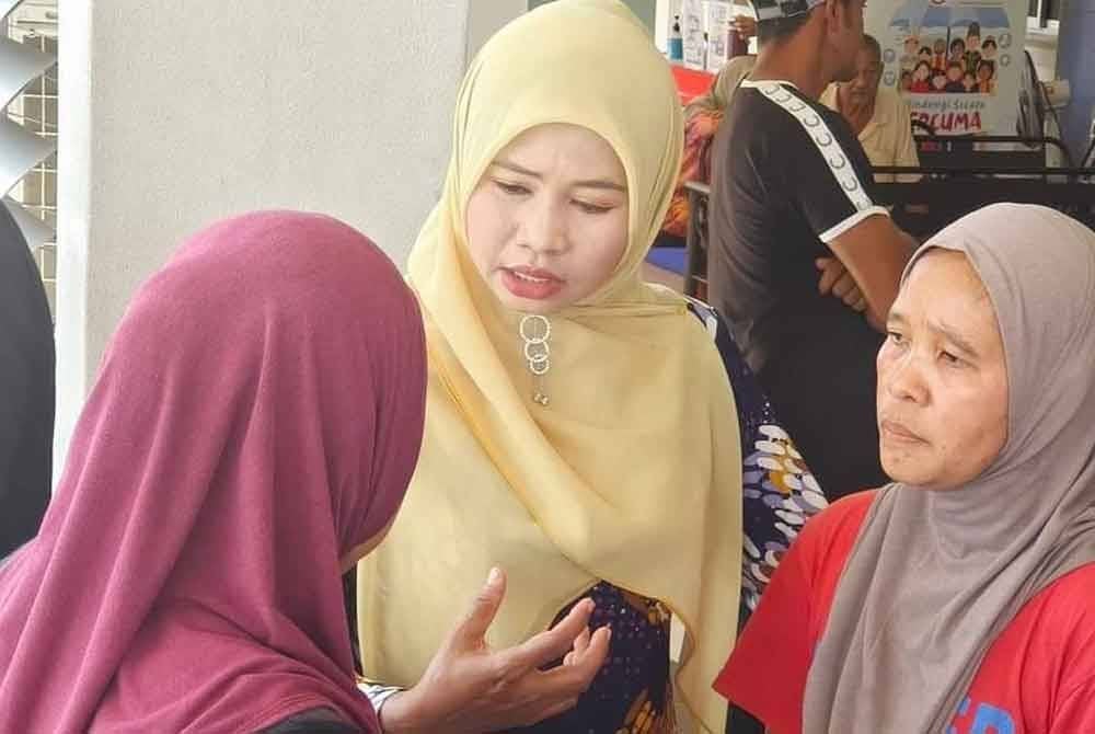 Norazilah (kanan) bersama Faridah (tengah) ketika menunggu bedah siasat dijalankan ke atas anak dan suaminya di Hospital Hulu Terengganu.