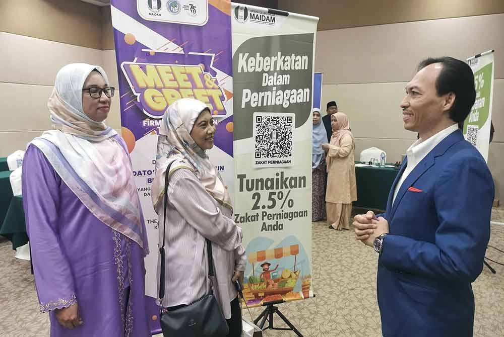 Ahmad Azrin (kanan) menerangkan sesuatu kepada peserta program 'Meet & Greet' MAIDAM bersama wakil firma perakaunan dan percukaian Terengganu, pada Selasa.
