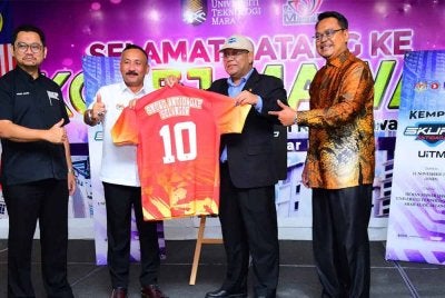 Ruslin (dua dari kiri) menyerahkan jersi kepada Mohd Sazili (dua dari kanan) sebagai simbolik kepada Pelancaran Kempen Skuad Antidadah UiTM di Dewan Mawar Qaseh, Kolej Kediaman Mawar, UiTM Shah Alam pada Selasa.