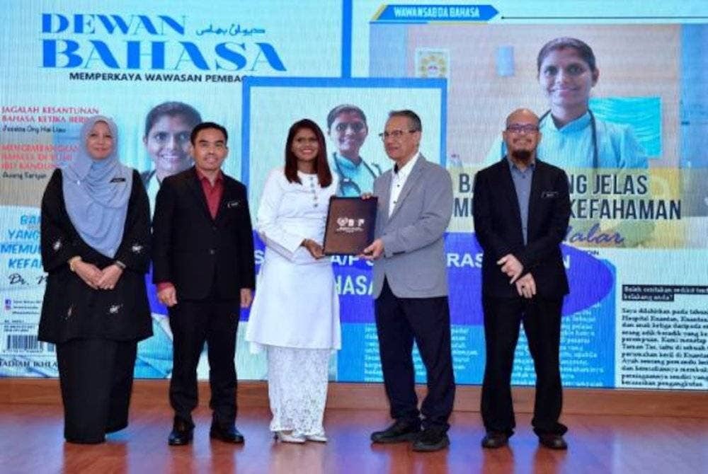 Pengerusi Lembaga Pengelola DBP Datuk SN Dr Anwar Ridwan (dua, kanan) menyampaikan watikah pelantikan sebagai ikon bahasa kepada Dr Malar, pada Majlis Apresiasi Citra DBP 2024 semalam. Turut mengiringi, Hazami (dua darikiri). Foto Facebook Hazami