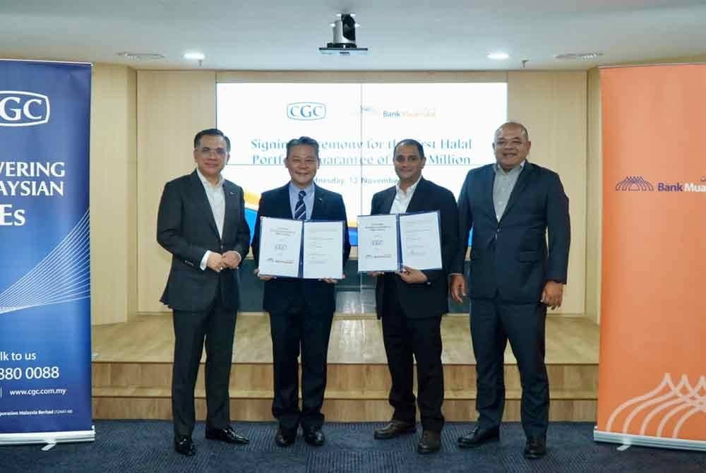 Khairul Kamarudin (kanan) menyaksikan majlis menandatangani pelancaran Skim Jaminan Portfolio-i Halal