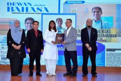 Pengerusi Lembaga Pengelola DBP Datuk SN Dr Anwar Ridwan (dua, kanan) menyampaikan watikah pelantikan sebagai ikon bahasa kepada Dr Malar, pada Majlis Apresiasi Citra DBP 2024 semalam. Turut mengiringi, Hazami (dua darikiri). Foto Facebook Hazami