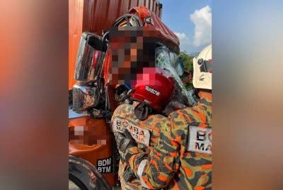Anggota bomba berusaha mengeluarkan mangsa yang tersepit dalam kejadian kemalangan di KM315.3 Lebuh raya Utara Selatan arah utara berhampiran Tapah pada Rabu.