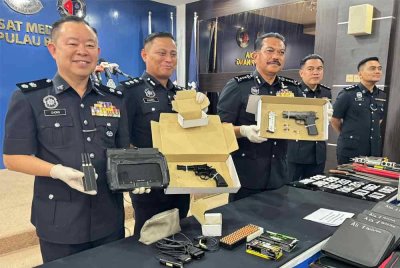 Hamzah (tiga dari kanan) menunjukkan senjata api yang ditemui di lokasi kejadian.