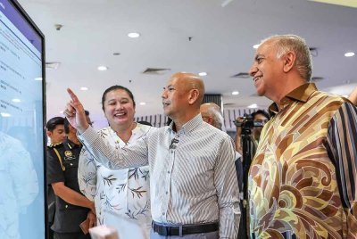 Armizan melihat skrin digital yang memaparkan aplikasi Price Catcher pada majlis menandatangani memorandum persefahaman perkongsian data harga antara KPDN dengan Mydin dan Redtick di Mydin, USJ 1 hari ini - Foto: Bernama