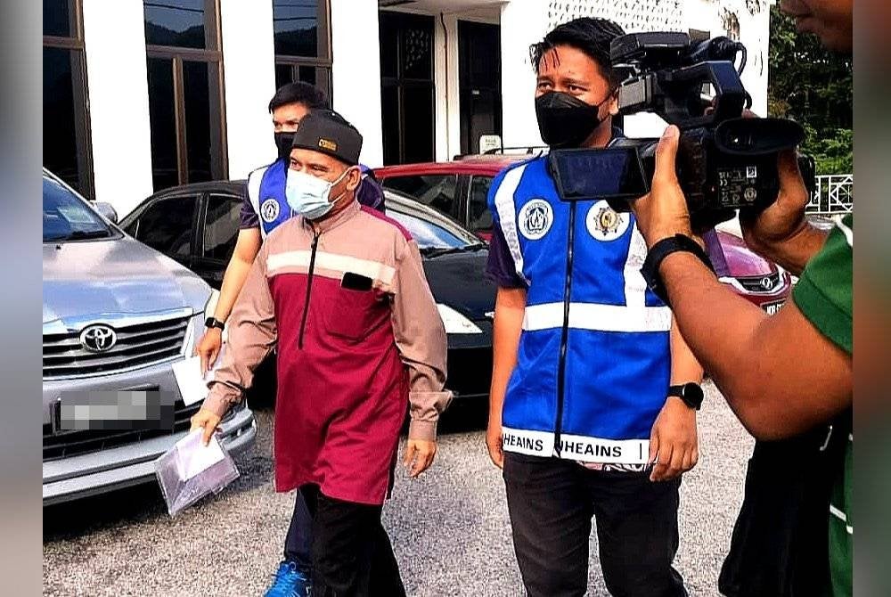 Muhammad Ghazalyi diiring penguat kuasa JHEAINS ketika hadir ke mahkamah.