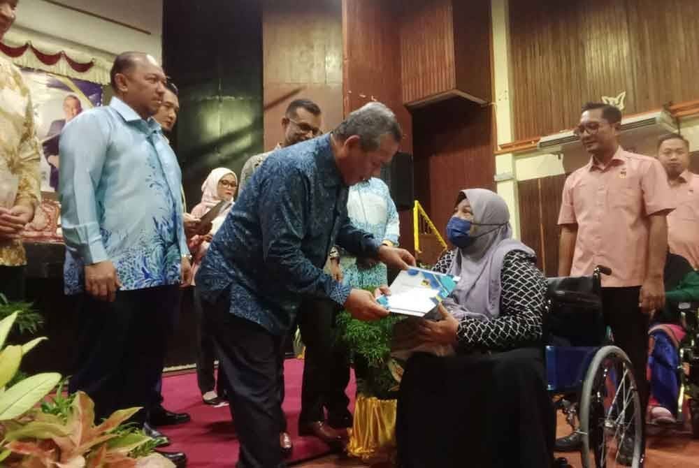 Aminuddin menyampaikan geran ha milik kepada peserta FELCRA terlibat.