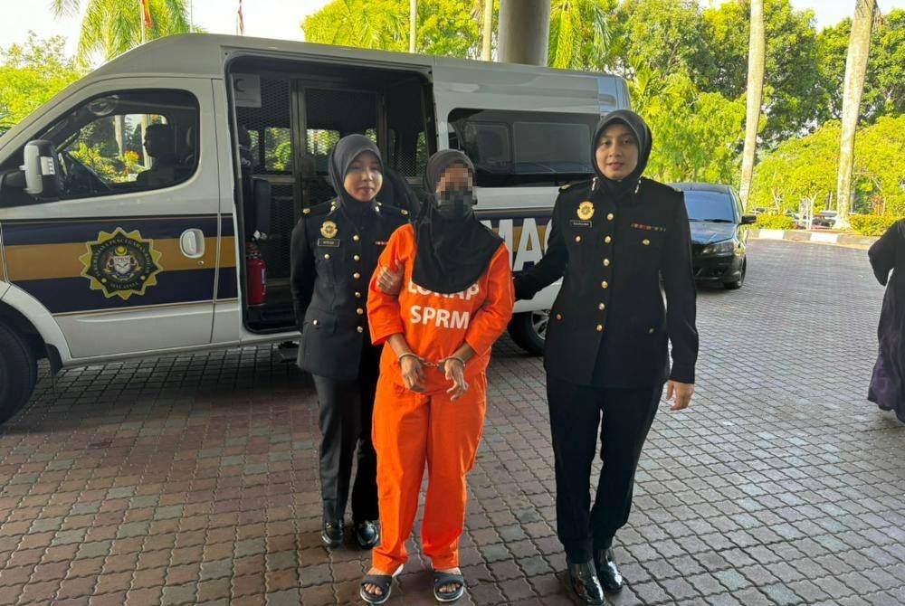 Dua pegawai SPRM mengiringi suspek semasa dibawa ke Mahkamah Majistret Shah Alam, Selangor bagi mendapatkan permohonan reman pada Khamis.