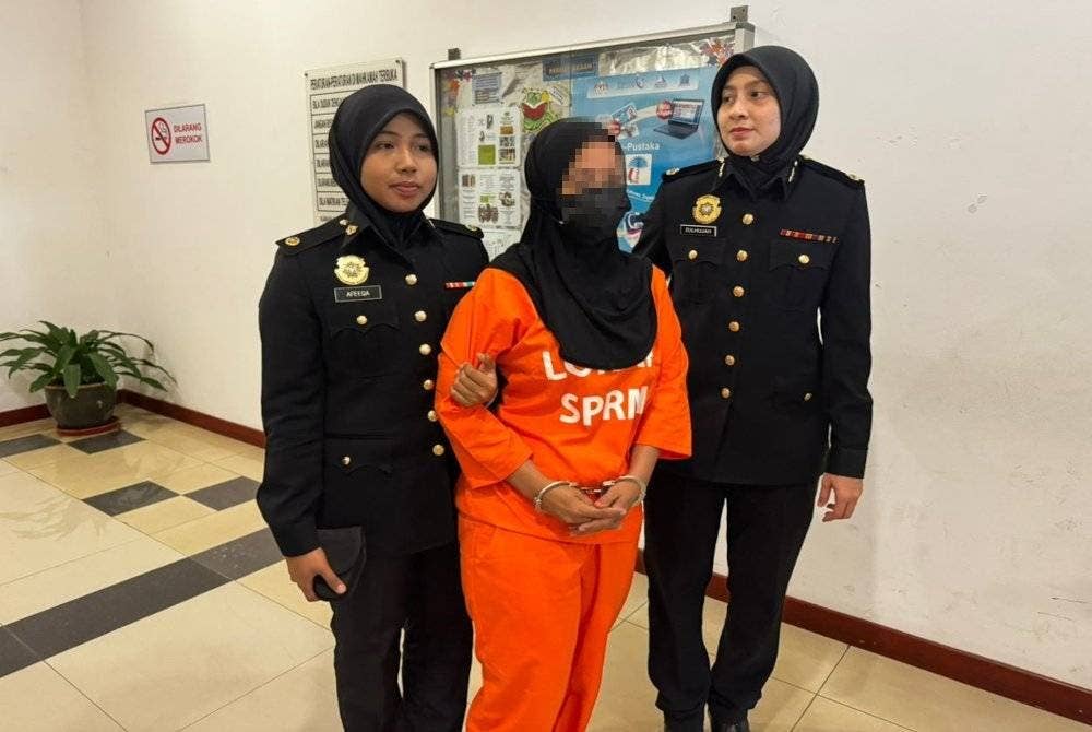 Dua pegawai SPRM mengiringi suspek semasa dibawa ke Mahkamah Majistret Shah Alam, Selangor bagi mendapatkan permohonan reman pada Khamis.