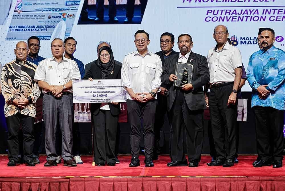 Steven (tengah) menyerahkan Anugerah Khas Menteri Sumber Manusia Tahun 2024 kepada Mohamed Shafie (tiga, kanan). Foto Bernama