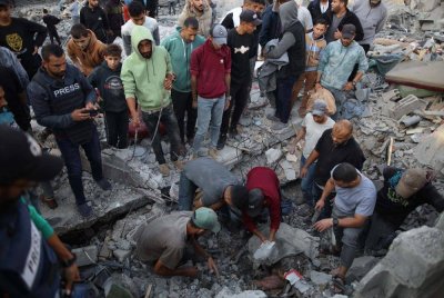 Orang ramai mencari di antara runtuhan bangunan yang musnah dalam serangan udara Israel di kem Nuseirat, tengah Semenanjung Gaza. Foto Xinhua