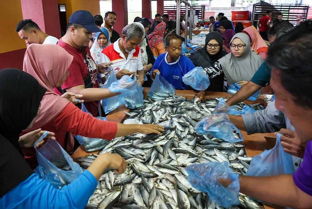 Penduduk setempat tidak melepaskan peluang mendapatkan ikan selayang pada harga 20 sen seekor di Pasar Kepong pada Jumaat. Foto Bernama