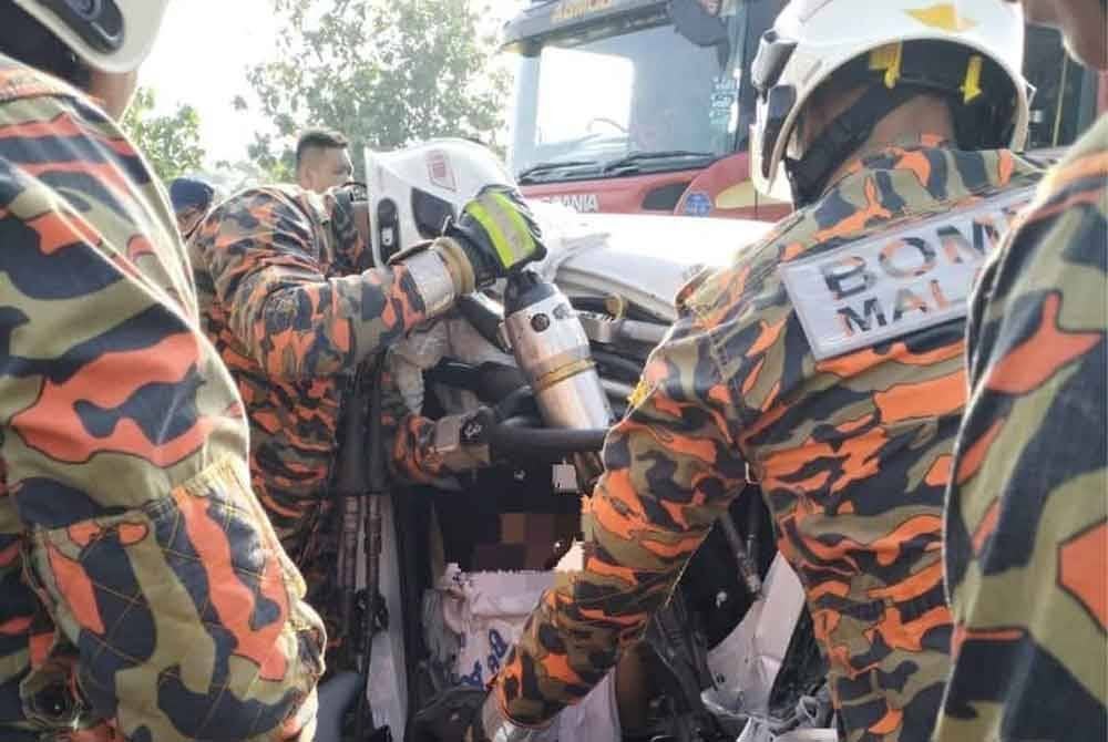 Anggota bomba mengeluarkan mangsa yang tersepit dalam nahas Kilometer (KM) 69.5, Lebuhraya Utara-Selatan arah utara berhampiran Machap. Foto JBPM