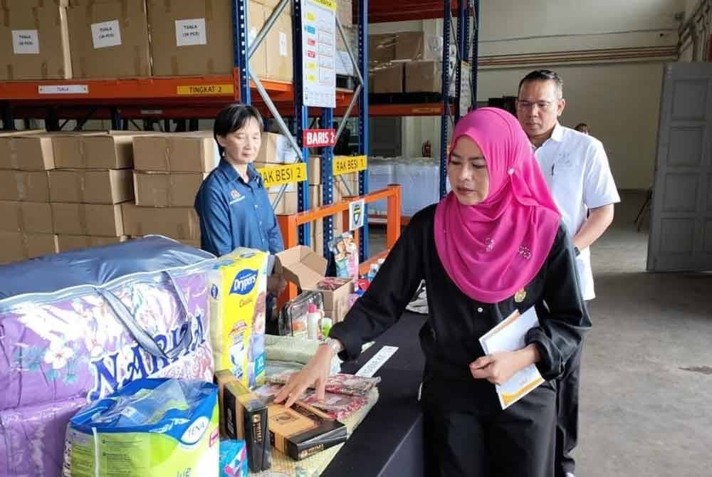Noraini menunjukkan antara barangan yang disediakan kepada mangsa banjir ketika melawat Depot Simpanan Bencana Banjir Pahang di Kampung Tiram di sini, pada Jumaat.