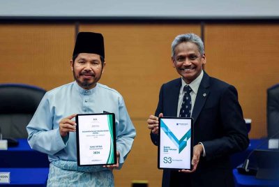 Gabenor BNM, Datuk Seri Shaik Abdul Rasheed Abdul Ghaffour (kanan) bersama Ketua Perangkawan Malaysia, Datuk Seri Dr Mohd Uzir Mahidin menunjukkan laporan KDNK dan Laporan Suku Tahunan BNM selepas sidang media Prestasi Ekonomi Suku Ketiga 2024 di Sasana Kijang pada Jumaat. Foto Bernama