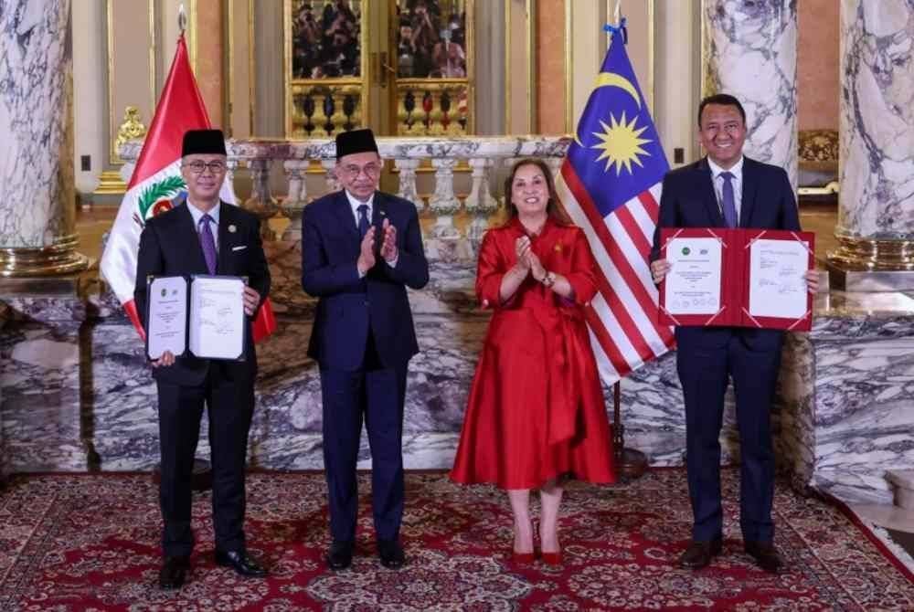 Anwar (dua dari kiri) dan Presiden Peru, Dina Ercilia Boluarte Zegarra (dua dari kanan) menyaksikan pertukaran memorandum persefahaman antara Tengku Zafrul (kiri) dan Menteri Pembangunan Pertanian dan Pengairan Peru, Angel Manuel Manero Campos di Istana Kerajaan pada Rabu.