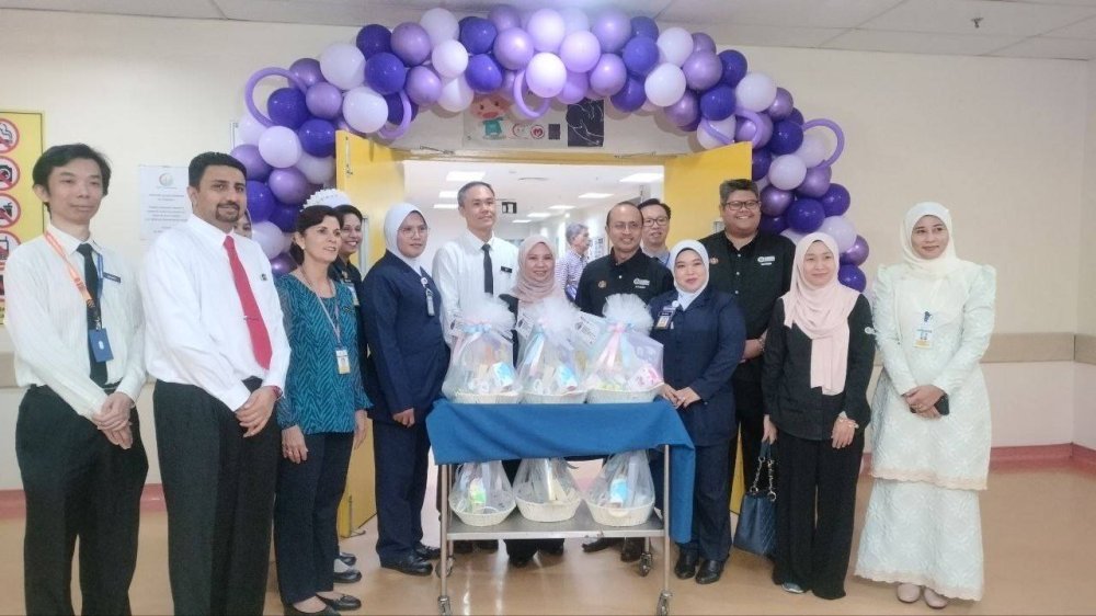 Norliza (tengah) bersama pegawai dan kakitangan Hospital Pulau Pinang menyantuni ibu dan bayi menerusi Program Junior Superhero Simpan SSPN, pada Jumaat.