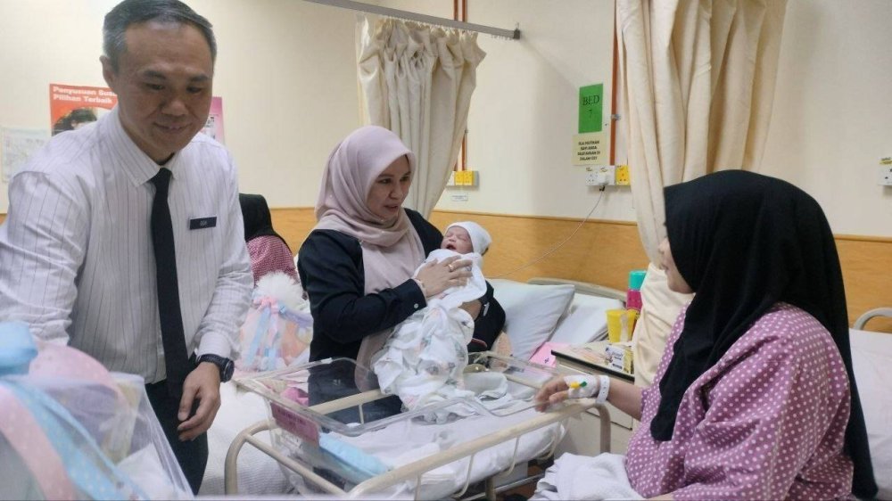 Norliza menyantuni seorang ibu bersama bayinya dalam Program Junior Superhero Simpan SSPN di Hospital Pulau Pinang.