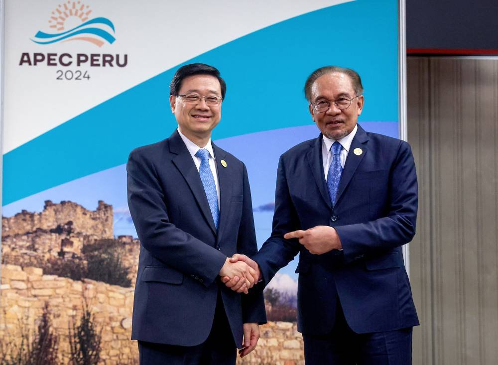 Anwar mengadakan pertemuan dua hala dengan Ketua Eksekutif Wilayah Pentadbiran Khas Hong Kong (HKSAR) John Lee Ka-chiu (kiri) di sela-sela Sidang Kemuncak APEC 2024 pada Jumaat. - Foto: Bernama