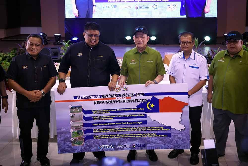 Fadillah (tiga dari kanan) menyerahkan replika senarai projek-projek siap kepada Ab Rauf (dua dari kiri) pada majlis Penyerahan Projek-projek Siap Kepada kerajaan negeri Melaka di MPAG hari ini. - Foto: Bernama