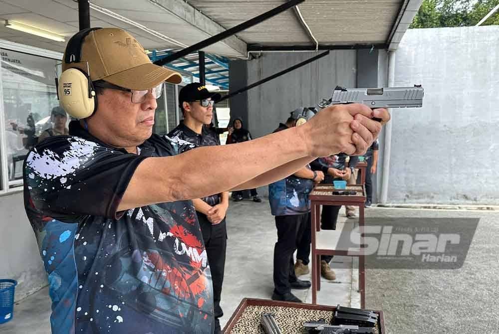 Azam menunjukkan kemahiran menembak semasa Program Menembak SPRM Bersama Media 2024 di Lapang Sasar Maktab Penjara Malaysia, Kajang pada Sabtu.