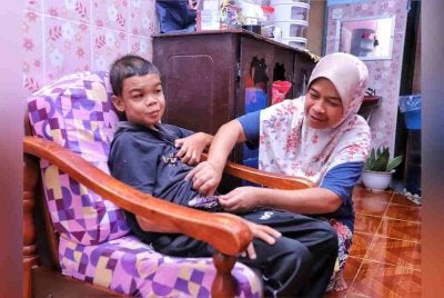 Rohaya disamping anaknya Muhammad Shukri yang mengidap buah pinggang kronik