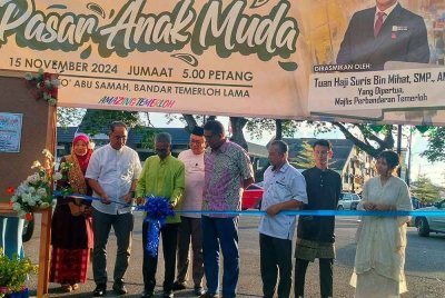 Suris (tiga dari kiri) bersama Afiqah (kanan) ketika memotong riben sebagai simbolik perasmian Pasar Anak Muda di Temerloh pada Jumaat.