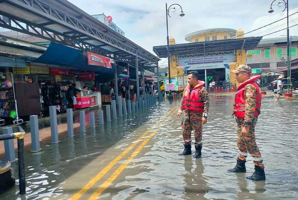 Anggota bomba membuat pemantauan di Pekan Kukup ketika fenomena air pasang besar pada pagi Ahad.