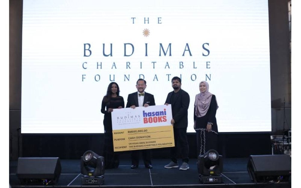 Tunku Yaacob (dua, kiri) dan Pegawai Eksekutif Budimas, Anne Rajasaikaran menerima replika cek sumbangan daripada salah satu penderma.