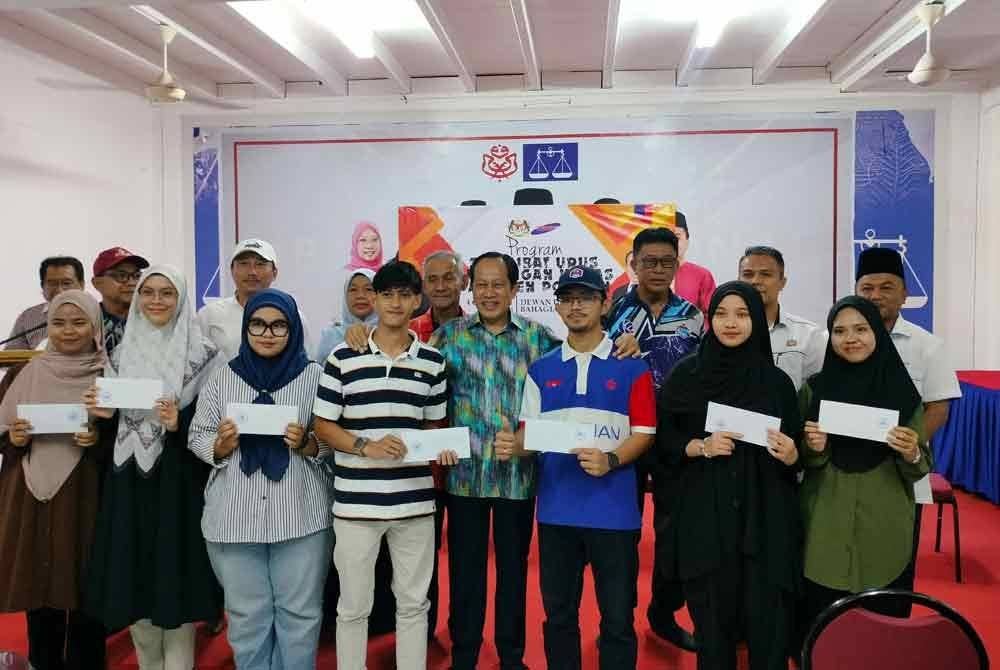 Ahmad Maslan (tengah) bergambar dengan sebahagian pelajar yang berjaya menyambung pelajaran ke IPT di Pejabat UMNO Pontian, pada petang Ahad.