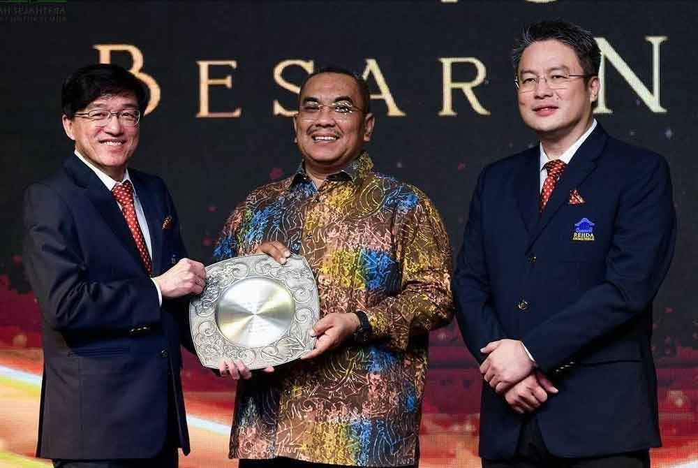 Ho Hon Sang (kiri) menyampaikan cenderahati kepada Sanusi pada majlis makan malam Rehda Kedah/Perlis pada Sabtu.