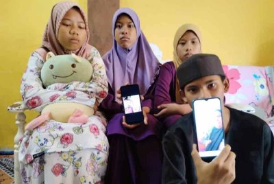 Anak-anak menunjukkan gambar kedua ibu bapa mereka yang maut dalam kemalangan.