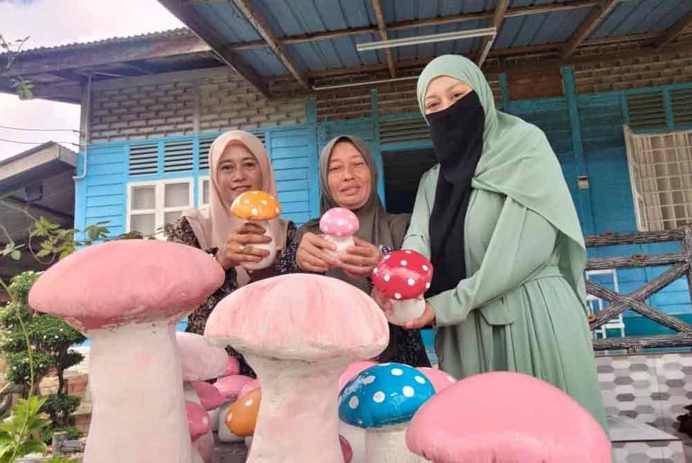 Noraini (tengah) menunjukkan cendawan yang mendapat permintaan daripada rakan dan pelanggan.