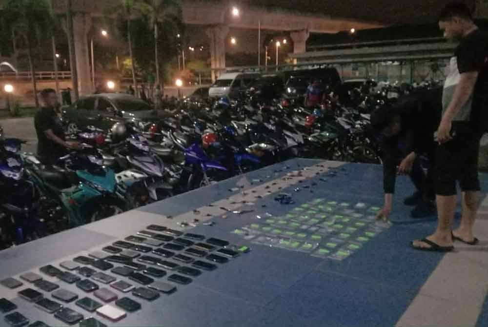 Pihak polis melakukan pemeriksaan ke atas penunggang dan pembonceng motosikal yang ditahan dalam Op Bersepadu Samseng Jalanan di Plaza Tol Batu 14 Puchong, Selangor pada Ahad. - Foto: PDRM