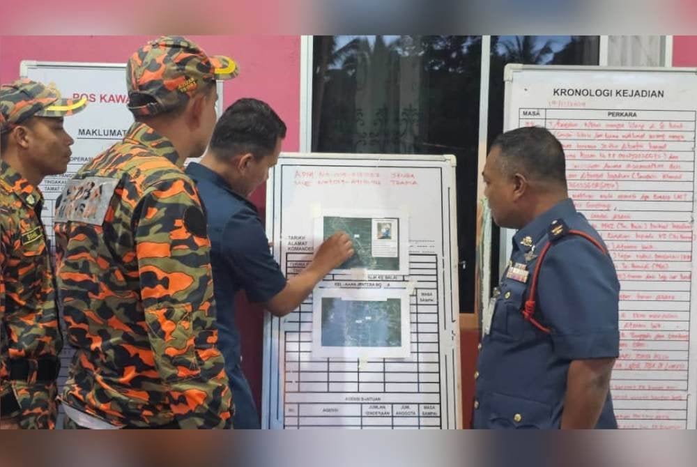 Sabarodzi (kanan) melihat perkembangan operasi SAR wanita dihanyutkan arus deras di Gerik.