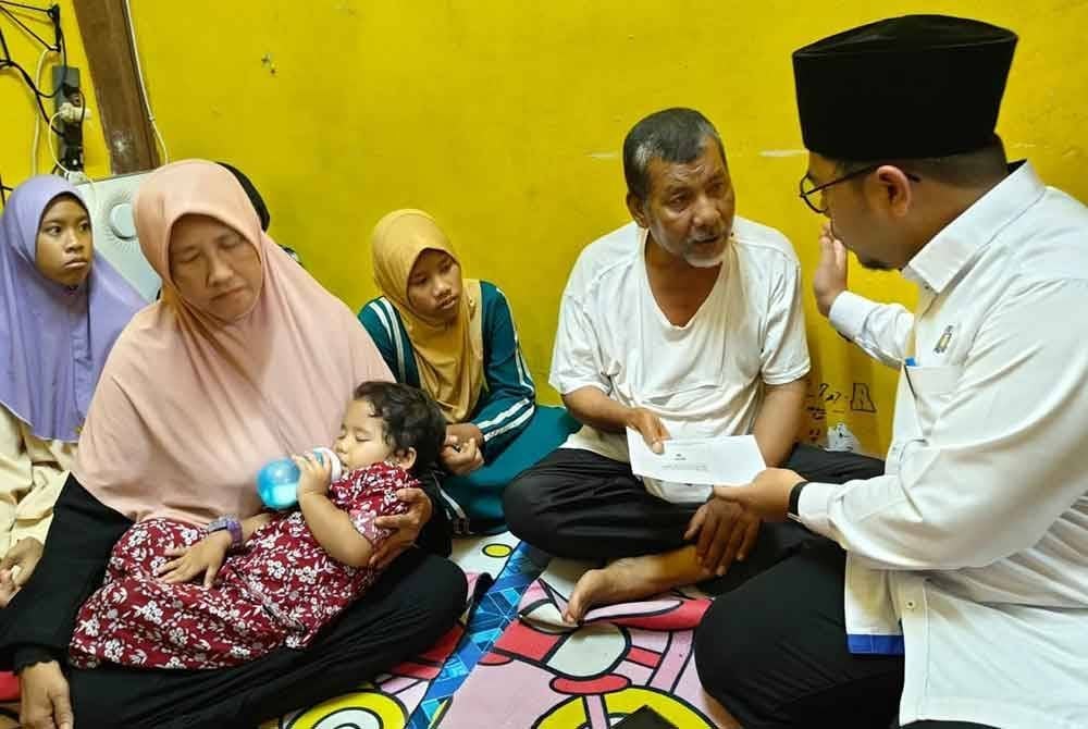 Mohd Firdaus menyampaikan sumbangan kepada datuk lima anak yatim piatu yang kematian Ibu bapanya di Flat Taman Cendana Pasir Gudang.