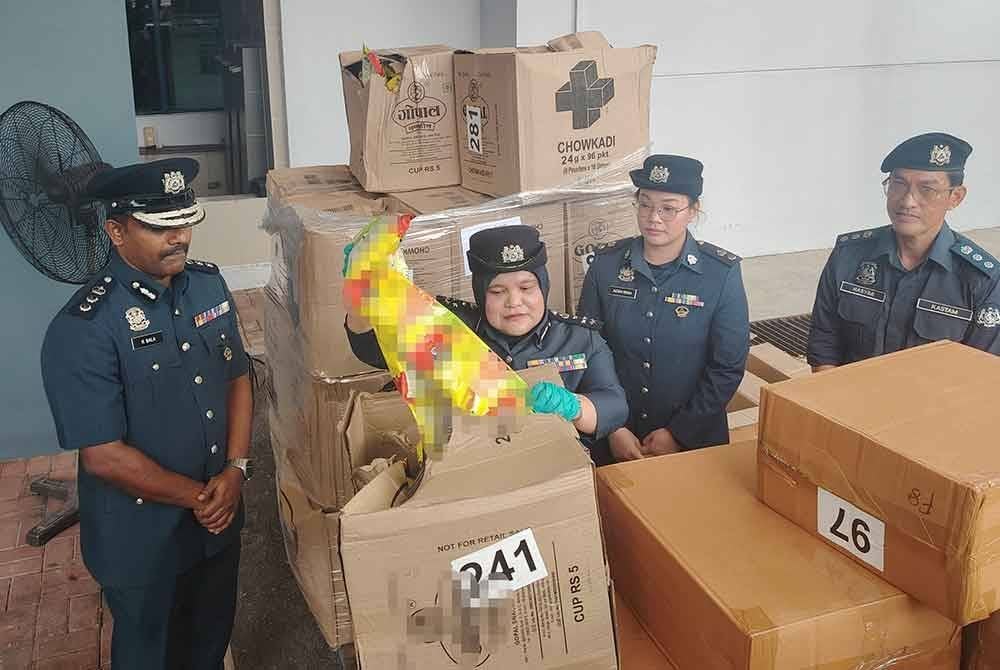 Raizam menunjukkan snek makanan yang dijumpai dalam kontena membawa rokok seludup semasa pemeriksaan di Pelabuhan Barat, Klang, 12 November lalu.