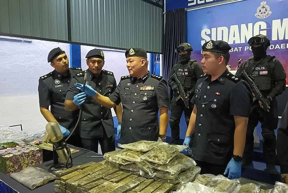 Naazron (tiga dari kiri) melihat alat menghisap dadah yang dirampas dalam tiga serbuan berasingan di sekitar Semenyih, Selangor pada Jumaat yang dianggarkan bernilai setengah juta.