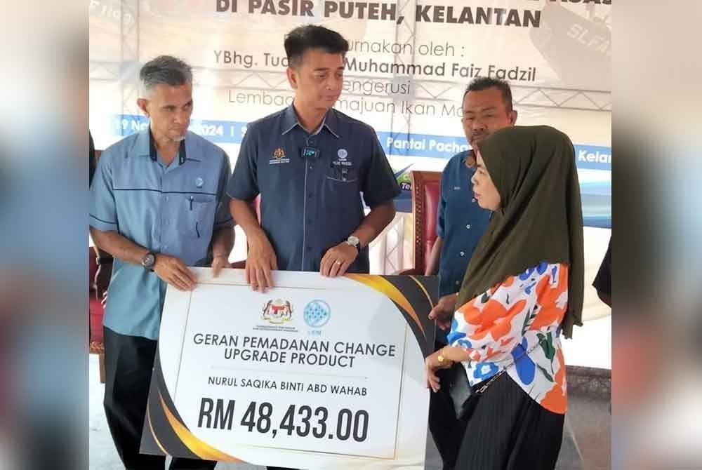 Muhammad Faiz (tengah) menyampaikan geran geran pemadanan 'change upgrade product' kepada seorang penerima.