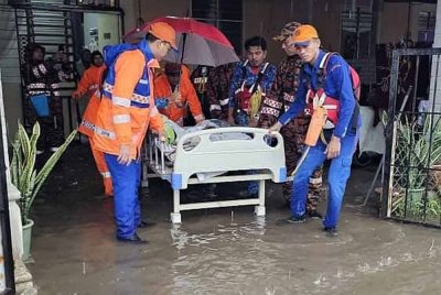 Anggota penyelamat memindahkan mangsa banjir di Rumah Mampu Milik (RMM) Teluk Kalong, Kemaman ke PPS Meraga Beris.