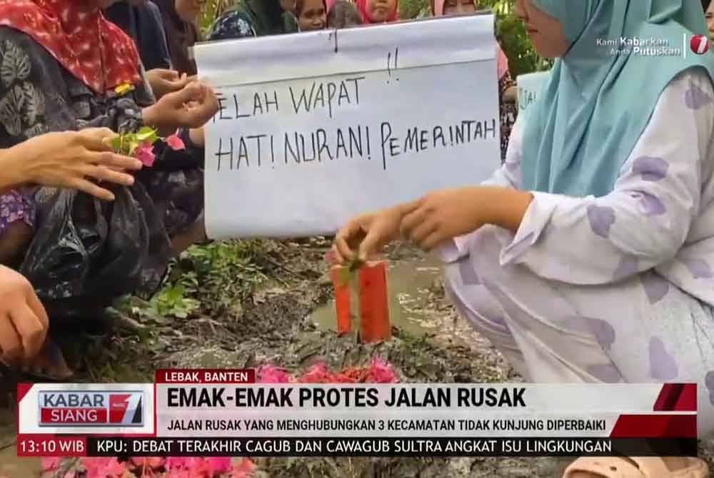 Penduduk membawa sepanduk tertulis 'telah wafat hati nurani pemerintah' selepas selesai 'membina' kubur di kawasan jalan rosak. Agensi