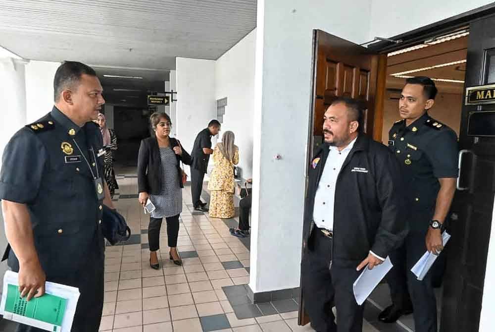 Zaini (dua dari kanan) ketika keluar dari Mahkamah Sesyen di sini, pada Rabu.