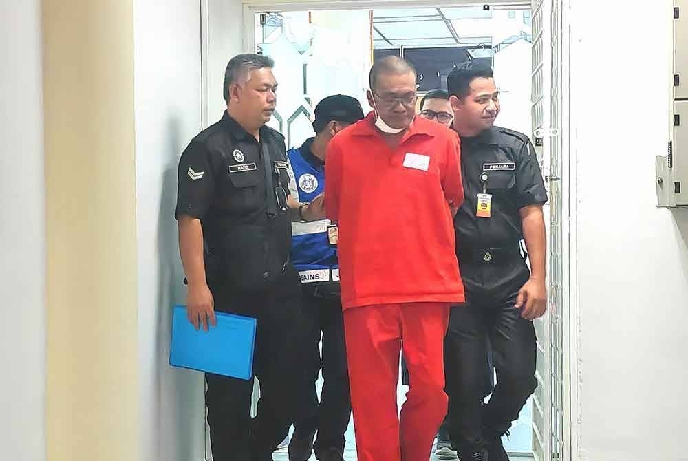 Idris diiring pegawai penjara ketika hadir ke mahkamah.