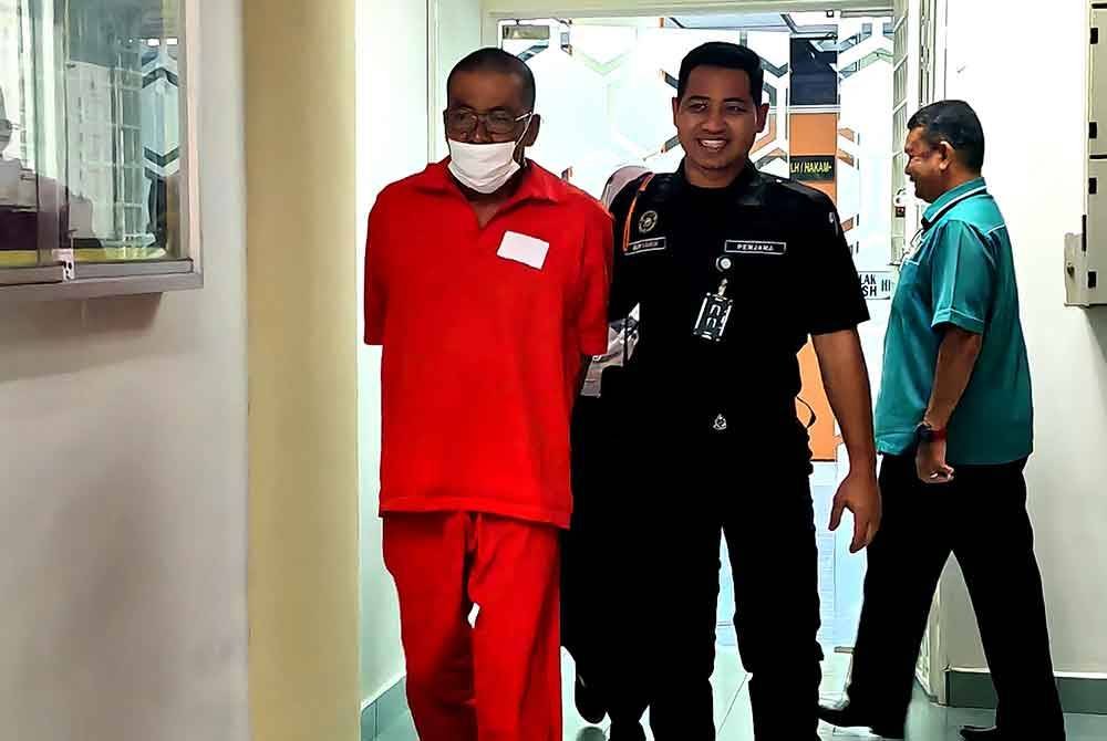 Idris diiring pegawai penjara ketika hadir ke mahkamah.