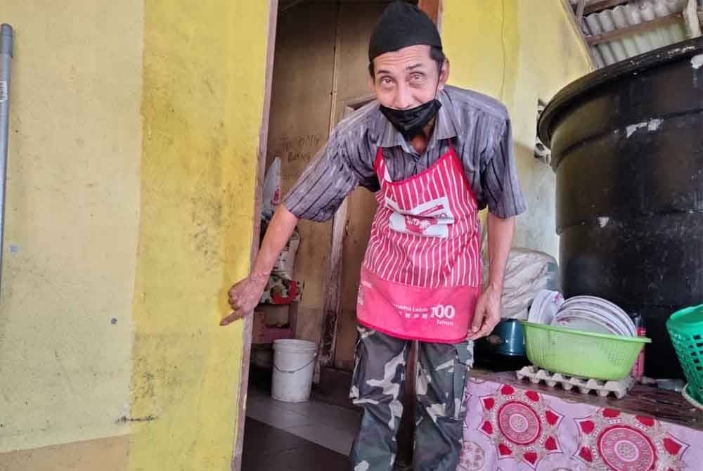 Azidra menunjukkan aras air di kedai makan isterinya ketika banjir pada 2022