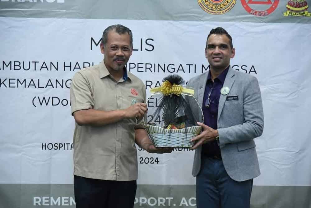 Mohd Yazid (kiri) menyerahkan cenderahati kepada wakil HSIS.