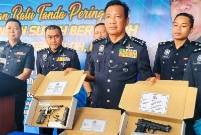 Yahaya (tengah) menunjukkan dua senjata api yang dirampas dalam kes serbuan di Bandar Pusat Jengka.